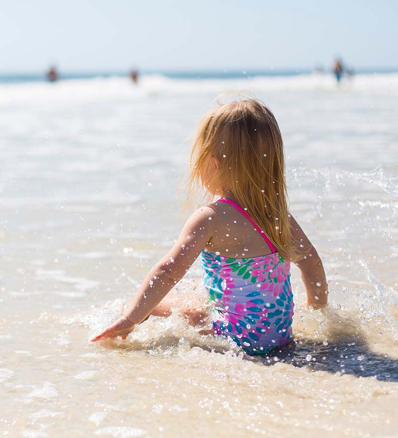 Little girl bathing by the sea on a beach near the campsite in Oléron