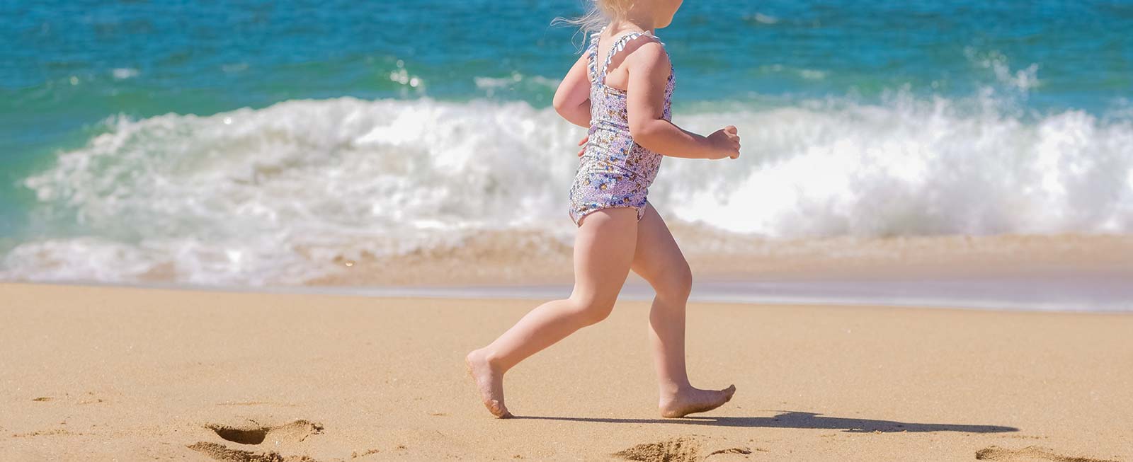 Petite fille courant proche de la mer sur une plage d'Oléron