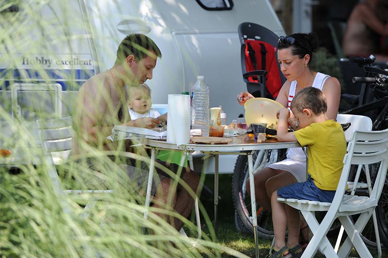 Family of campers having lunch outdoors at the campsite in Oléron