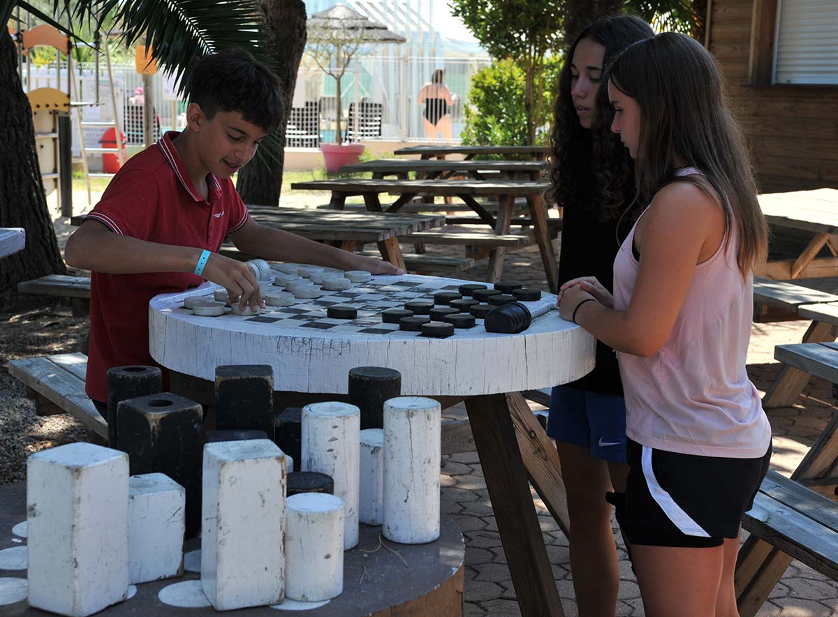 Children playing chess outdoors at the campsite in Oléron