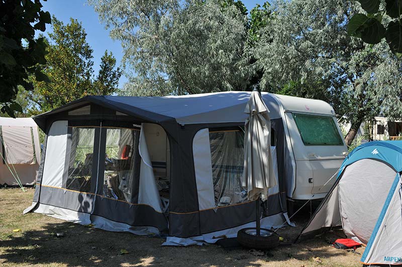Caravane et sa terrasse sur un emplacement de camping à Oléron
