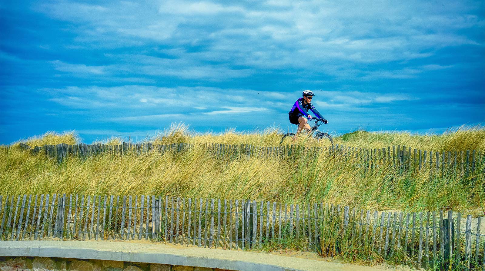 Cycliste sur une dune en bord de mer à Oléron