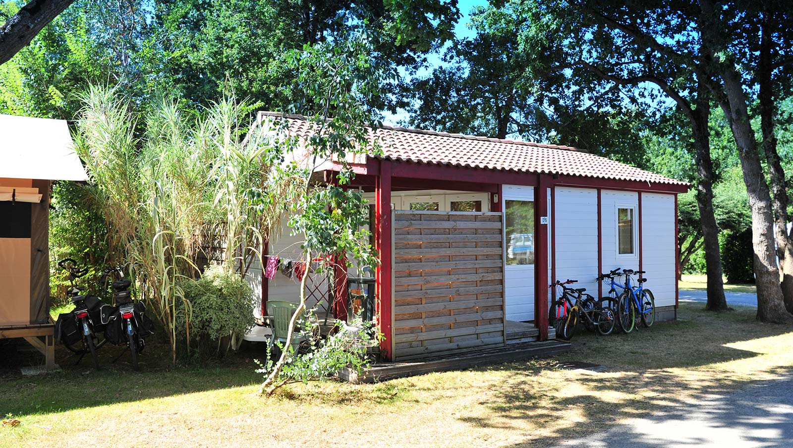 Chalet under the large trees in the campsite park in Oléron