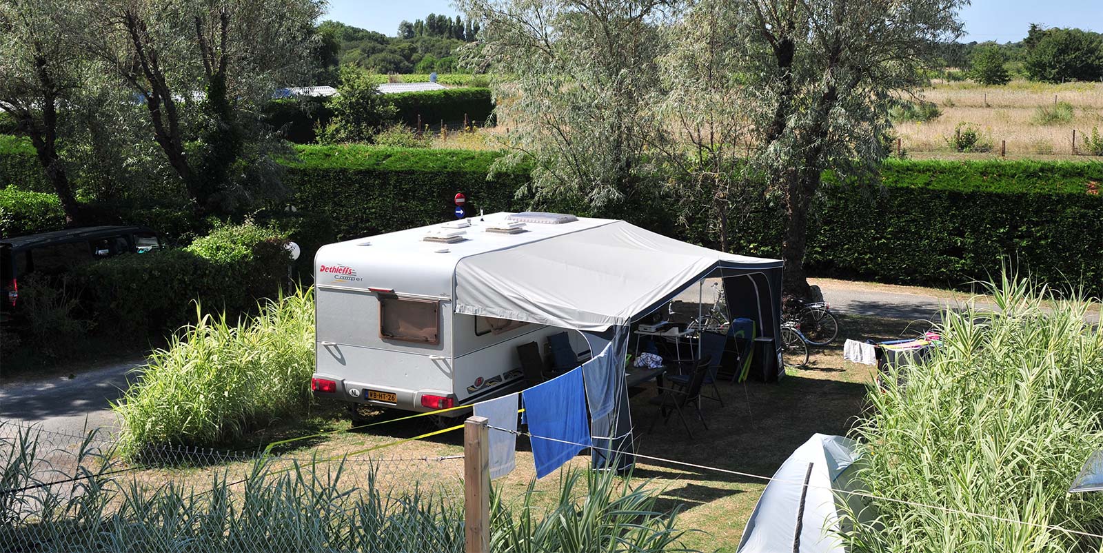 Caravane et sa terrasse sur un emplacement de camping à Oléron