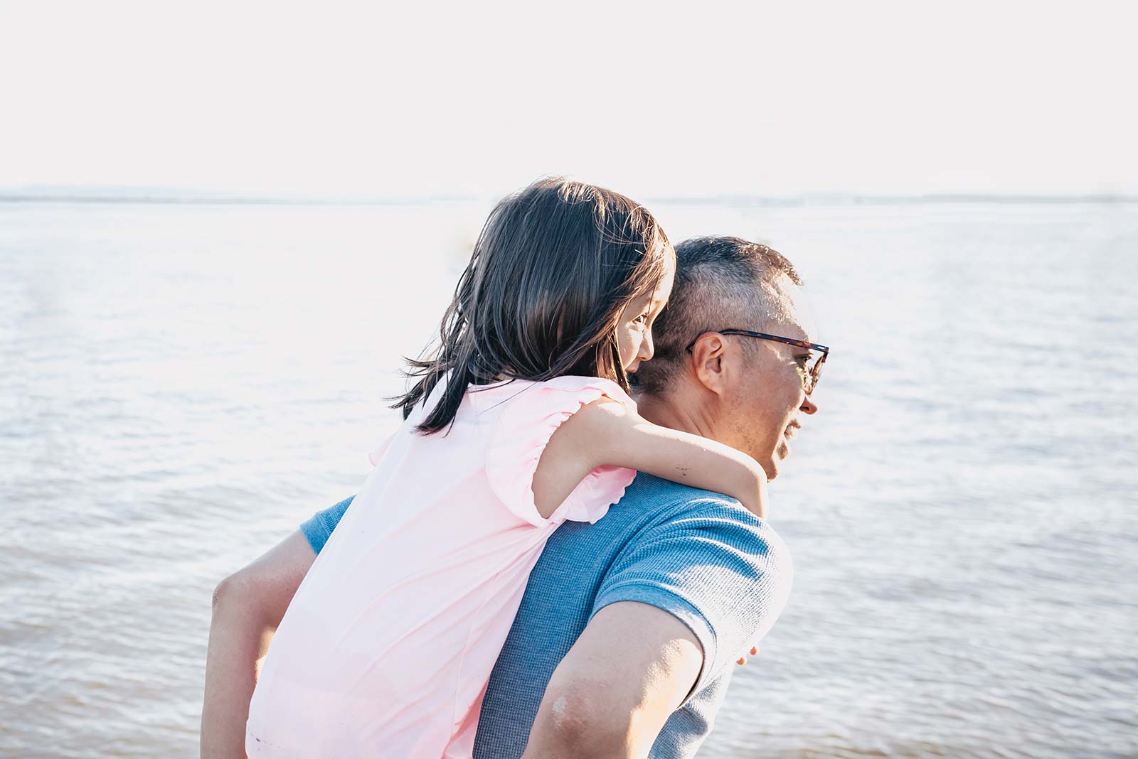 Grandfather and his granddaughter in front of the Atlantic Ocean in Oléron