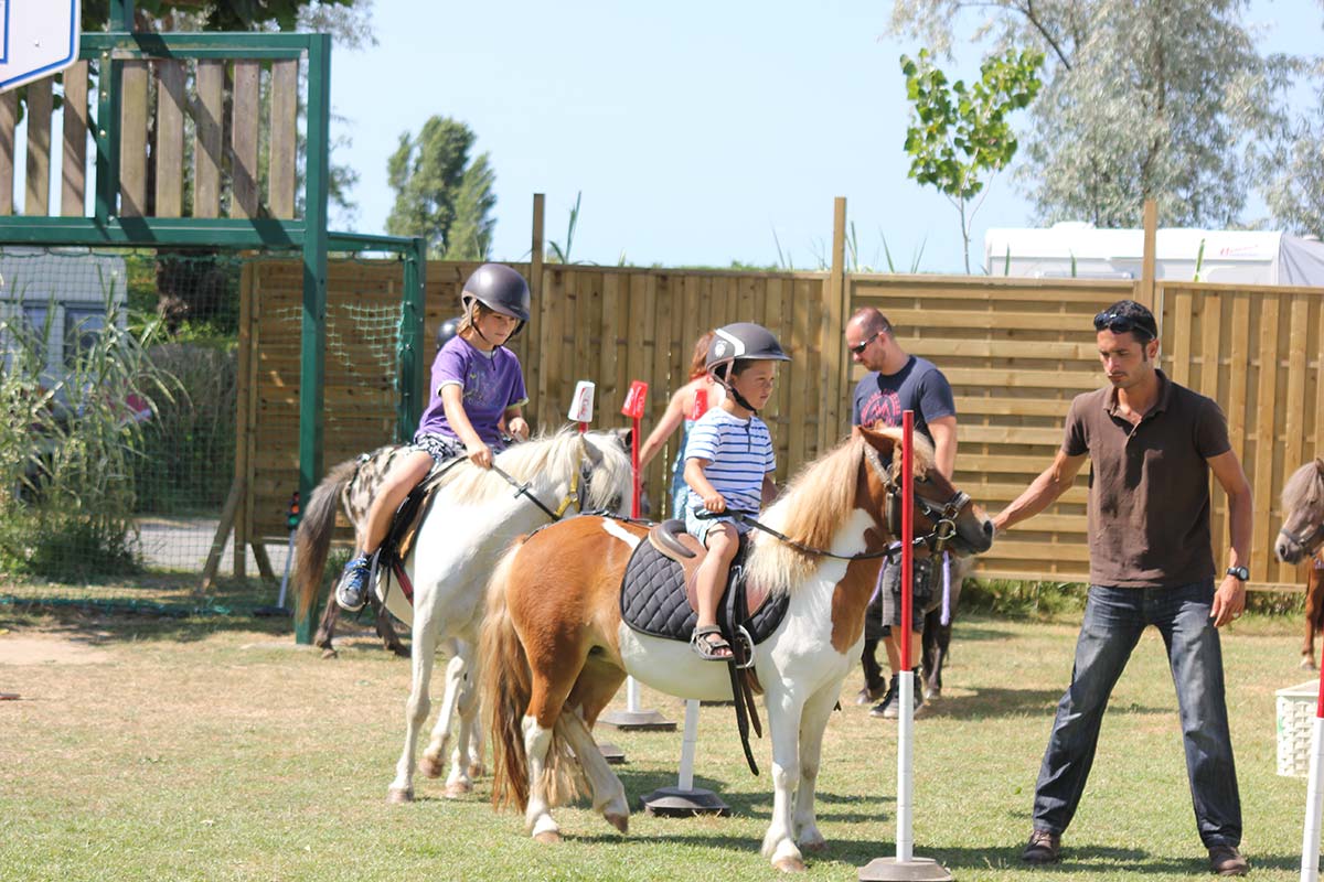 Enfants s'initiant au poney au camping à Oléron