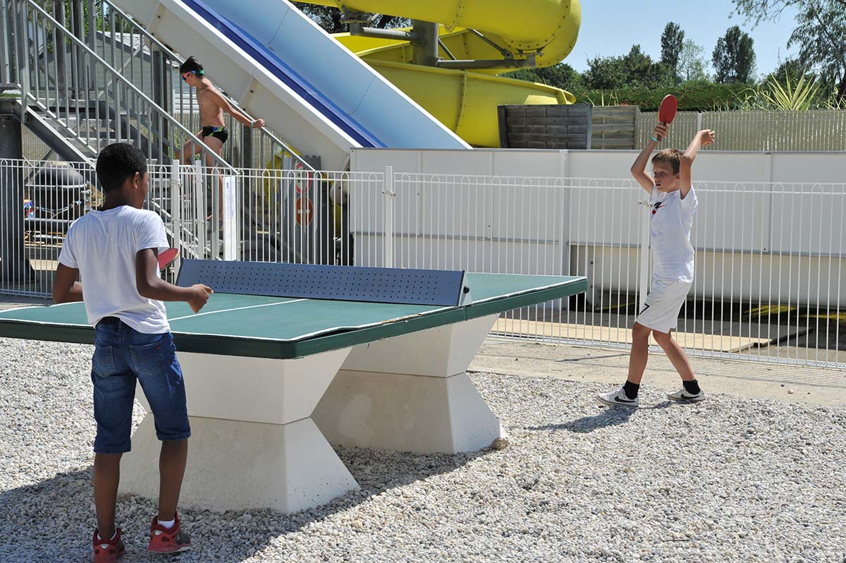 Campeurs jouant au ping-pong sur les tables extérieurs au camping à Oléron