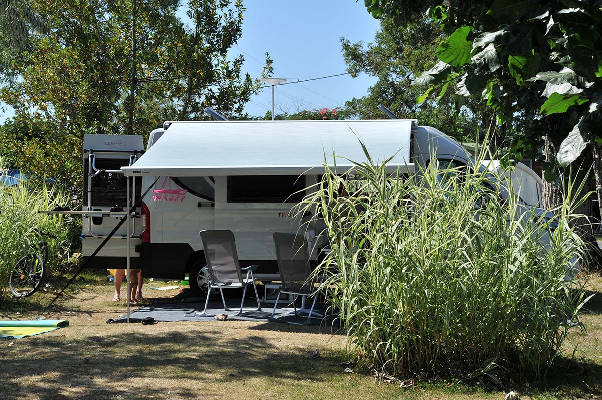 Camping-car sur son emplacement ombragé au camping à Oléron